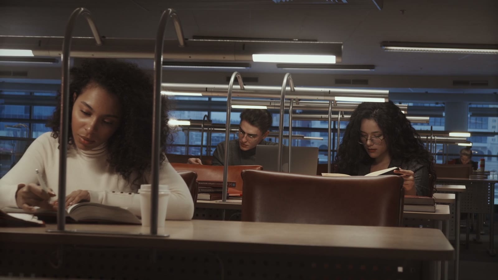 Students reading and writing in a university library